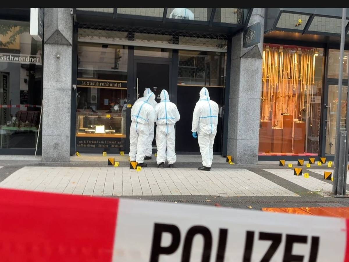 Ermittler stehen vor einem Uhrengeschäft.