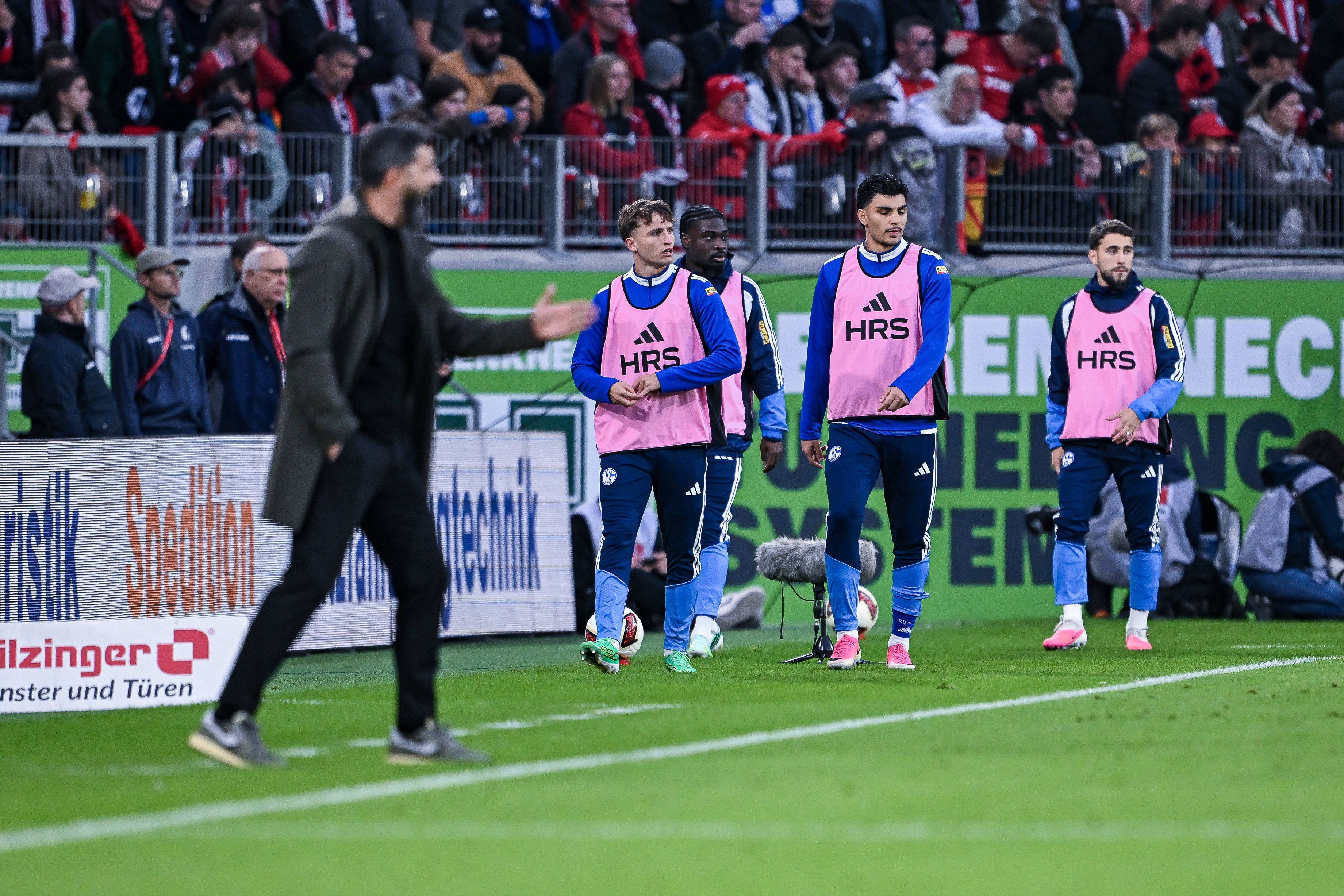 Mertcan Ayhan mit Teamkollegen und Trainer am Spielfeldrand