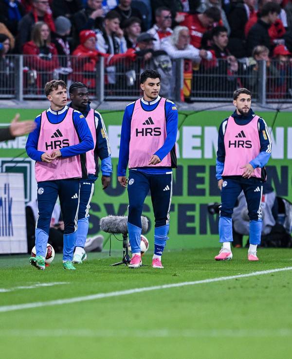 Mertcan Ayhan mit Teamkollegen und Trainer am Spielfeldrand