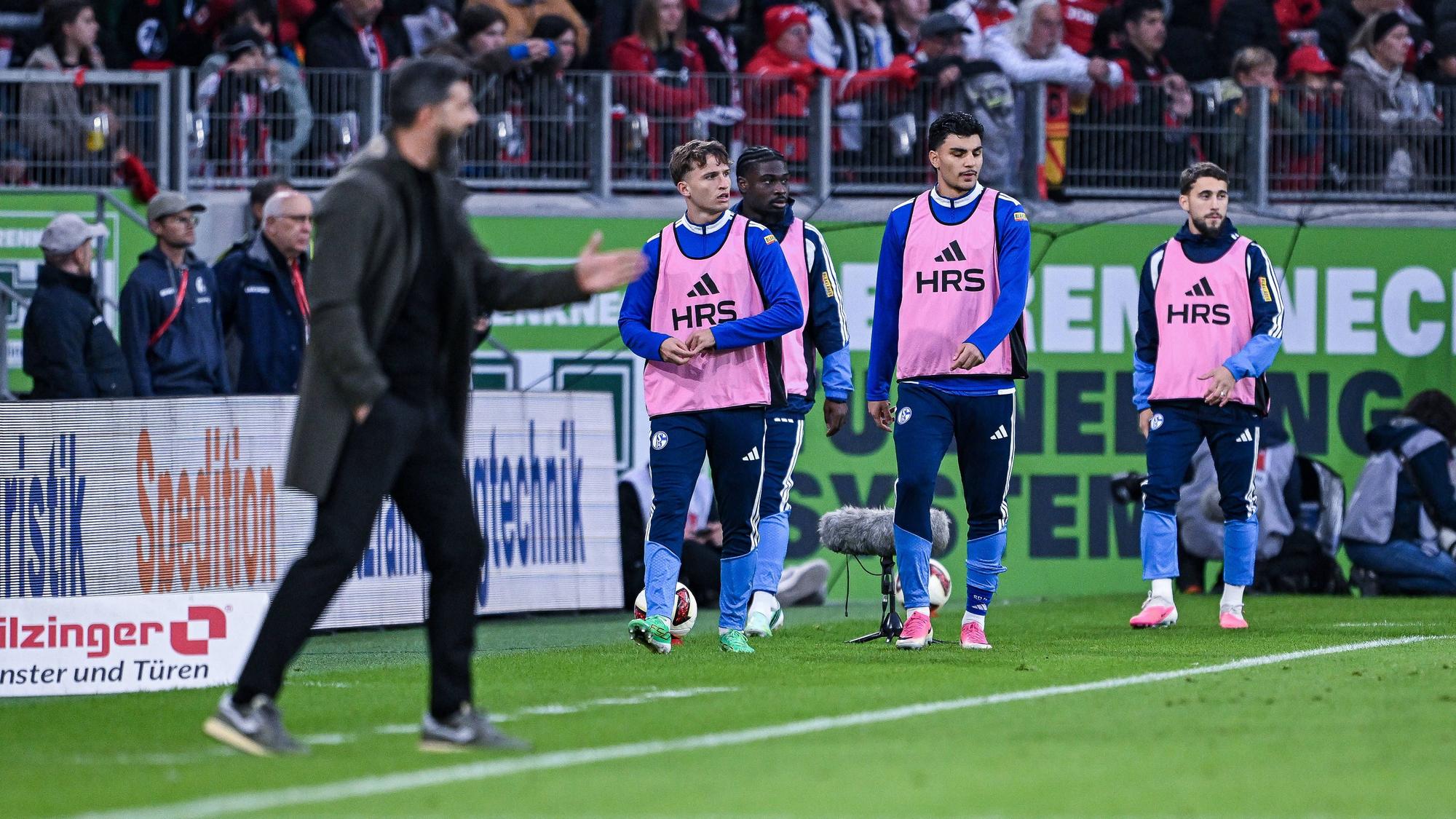 Mertcan Ayhan mit Teamkollegen und Trainer am Spielfeldrand