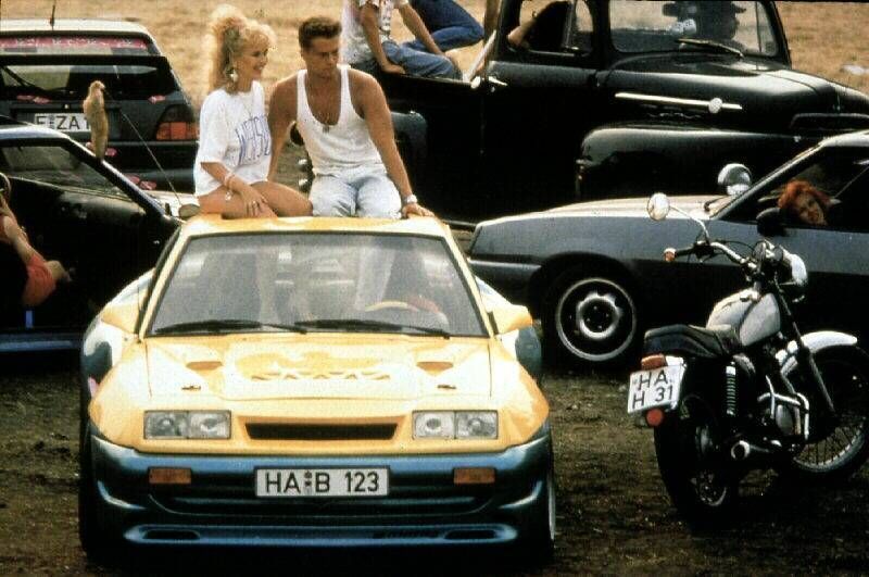 Tina Ruland, Til Schweiger Berti (Til Schweiger), der einen heissgemachten Manta B GTE faehrt, ist mit Uschi (Tina Ruland) und der Clique unterwegs. 1991 UnitedArchives01356386

Tina Ruland Til Schweiger Berti Til Schweiger the a  Manta B GTE runs is with Uschi Tina Ruland and the Clique on the road 1991 UnitedArchives01356386