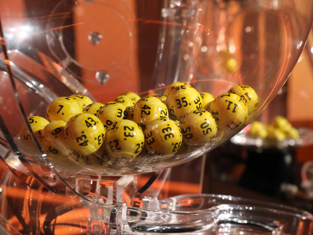 Lotto-Ziehungsmaschine mit gelben Kugeln im Fernsehstudio.