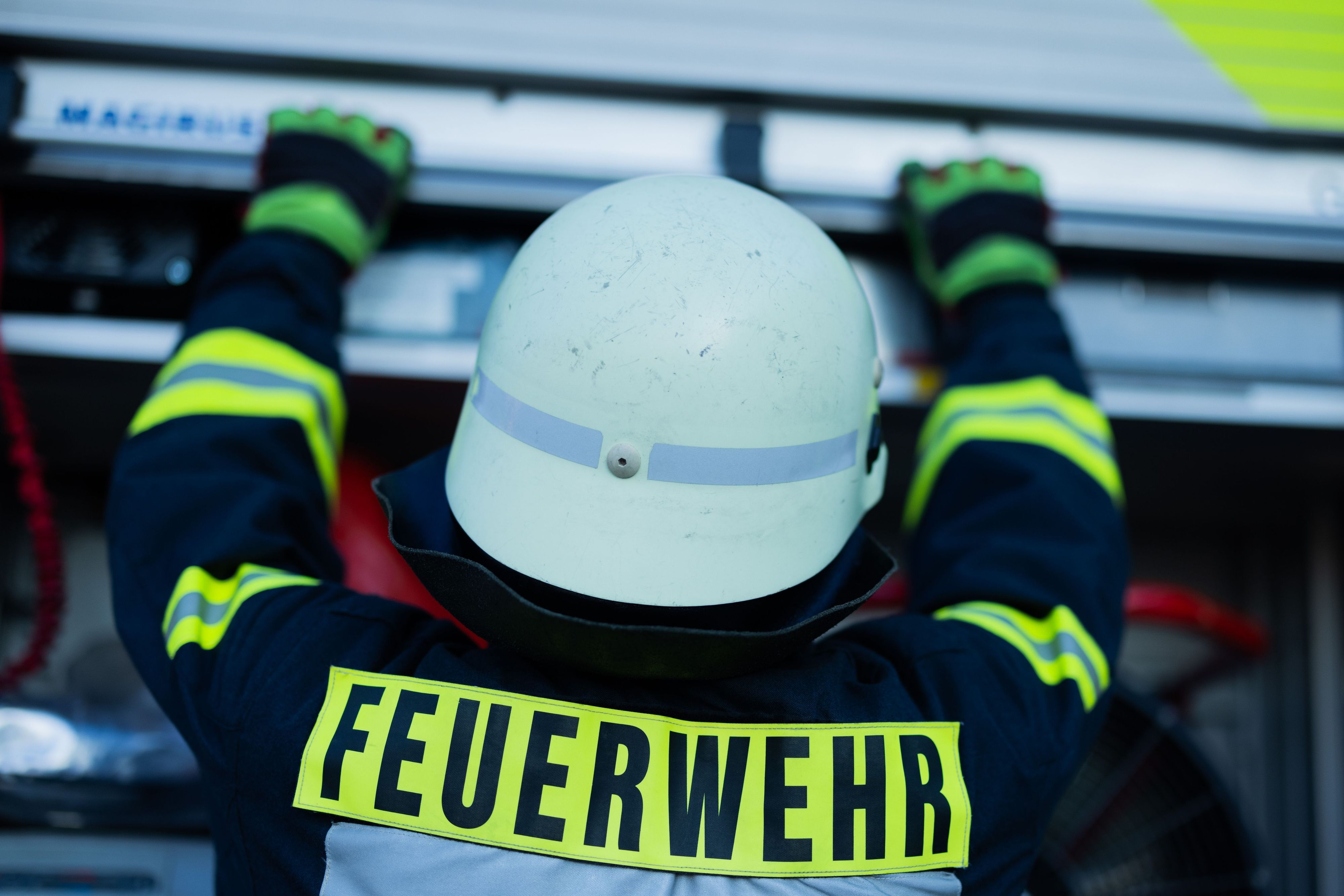 ARCHIV - 11.01.2024, Nordrhein-Westfalen, Leverkusen: Ein Feuerwehrmann holt Equipment aus einem Einsatzfahrzeug an der Feuerwache der Feuerwehr. (zu dpa: «36-Jähriger schläft im Auto - dann steht es in Flammen») Foto: Rolf Vennenbernd/dpa +++ dpa-Bildfunk +++