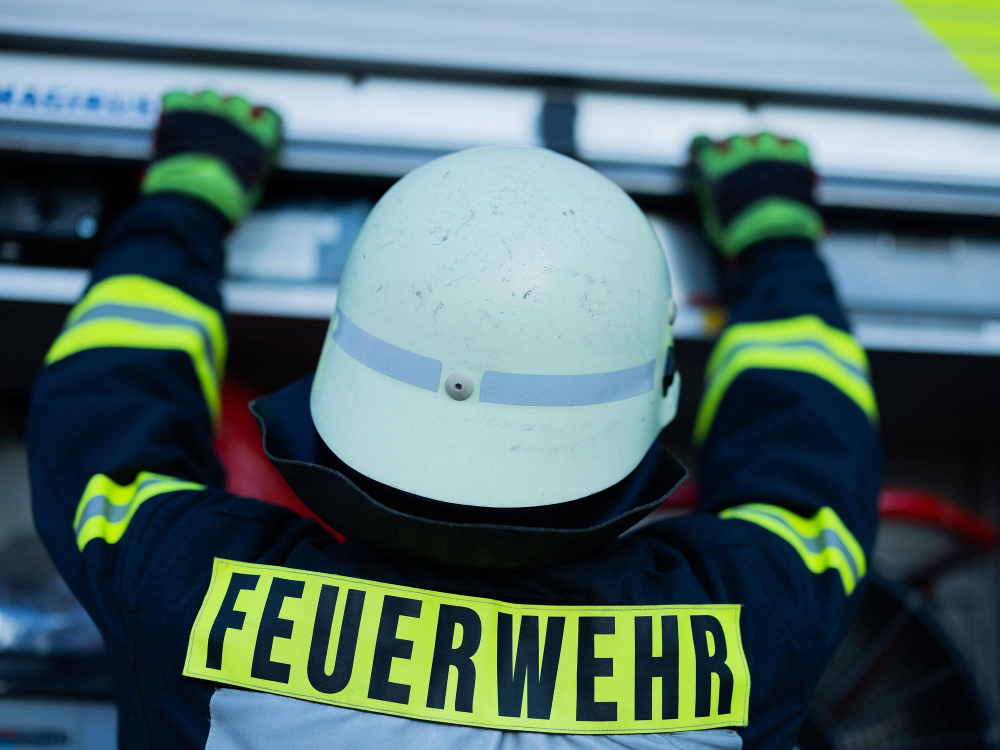 ARCHIV - 11.01.2024, Nordrhein-Westfalen, Leverkusen: Ein Feuerwehrmann holt Equipment aus einem Einsatzfahrzeug an der Feuerwache der Feuerwehr. (zu dpa: «36-Jähriger schläft im Auto - dann steht es in Flammen») Foto: Rolf Vennenbernd/dpa +++ dpa-Bildfunk +++