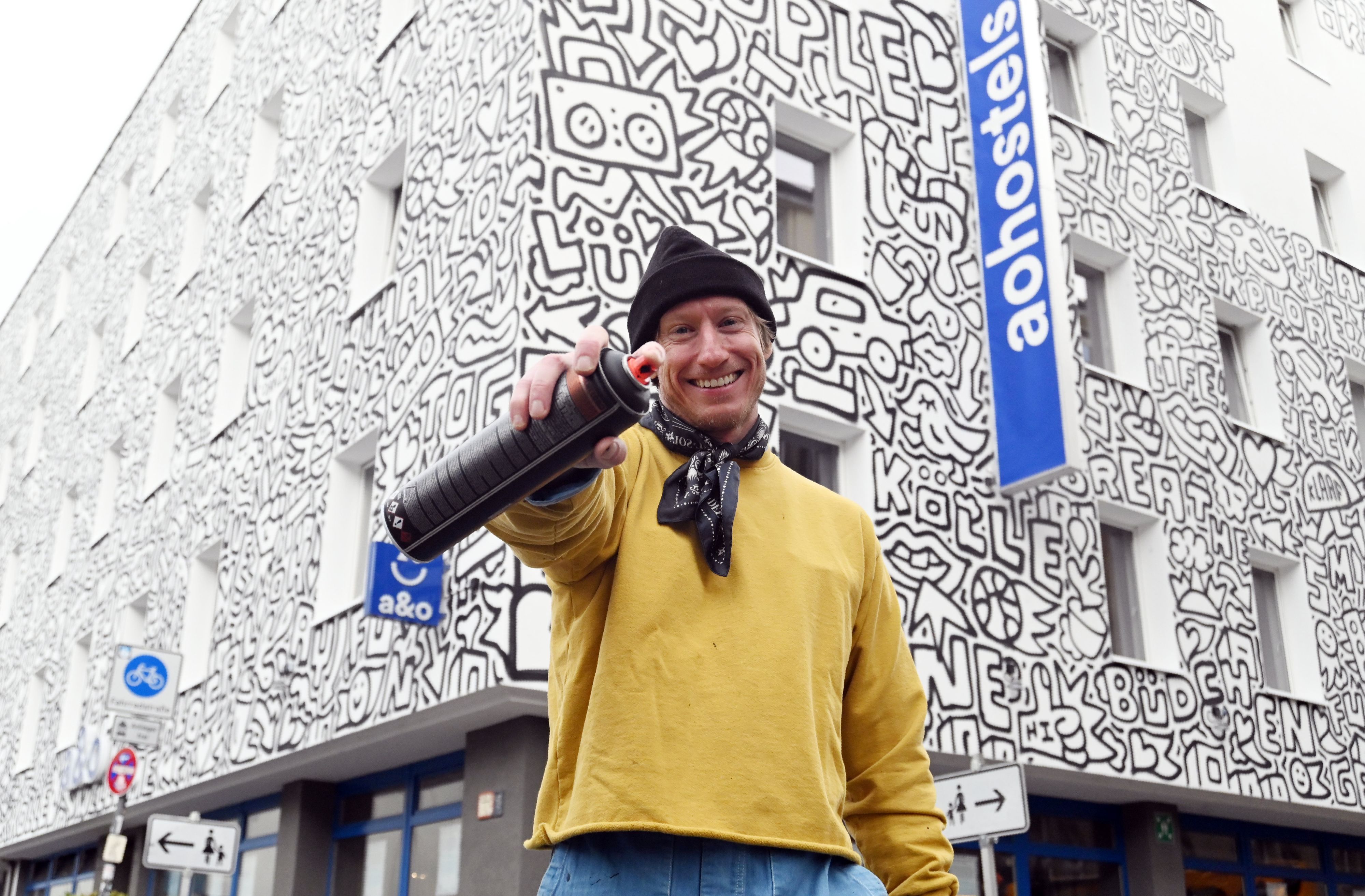 22.10.2026 Köln. Der New Yorker Künstler Timothy Goodman gestaltet mit seinem Werk „People Love People“ die Fassade des a&o Hostels Köln Neumarkt. Foto: Alexander Schwaiger