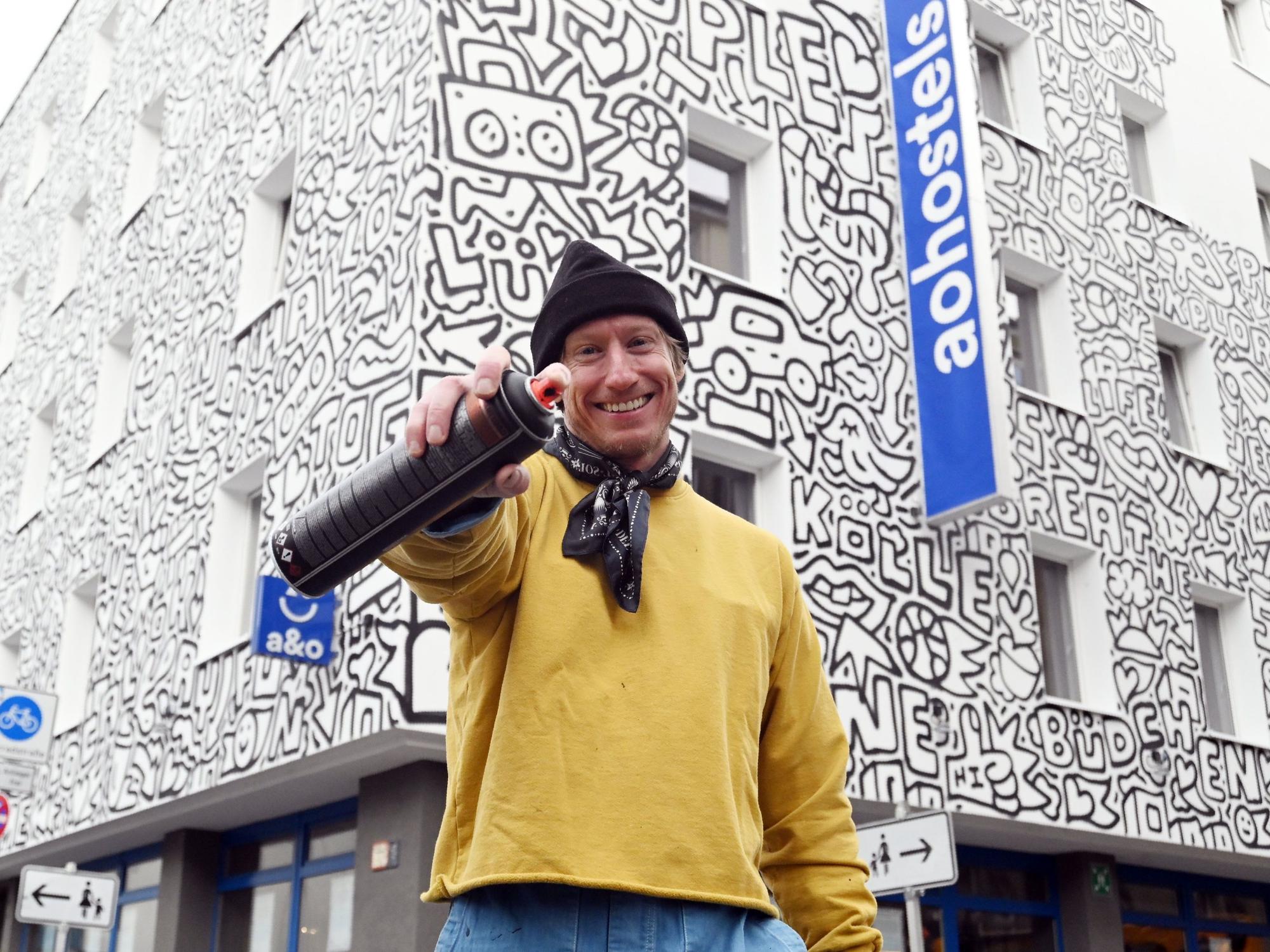22.10.2026 Köln. Der New Yorker Künstler Timothy Goodman gestaltet mit seinem Werk „People Love People“ die Fassade des a&o Hostels Köln Neumarkt. Foto: Alexander Schwaiger