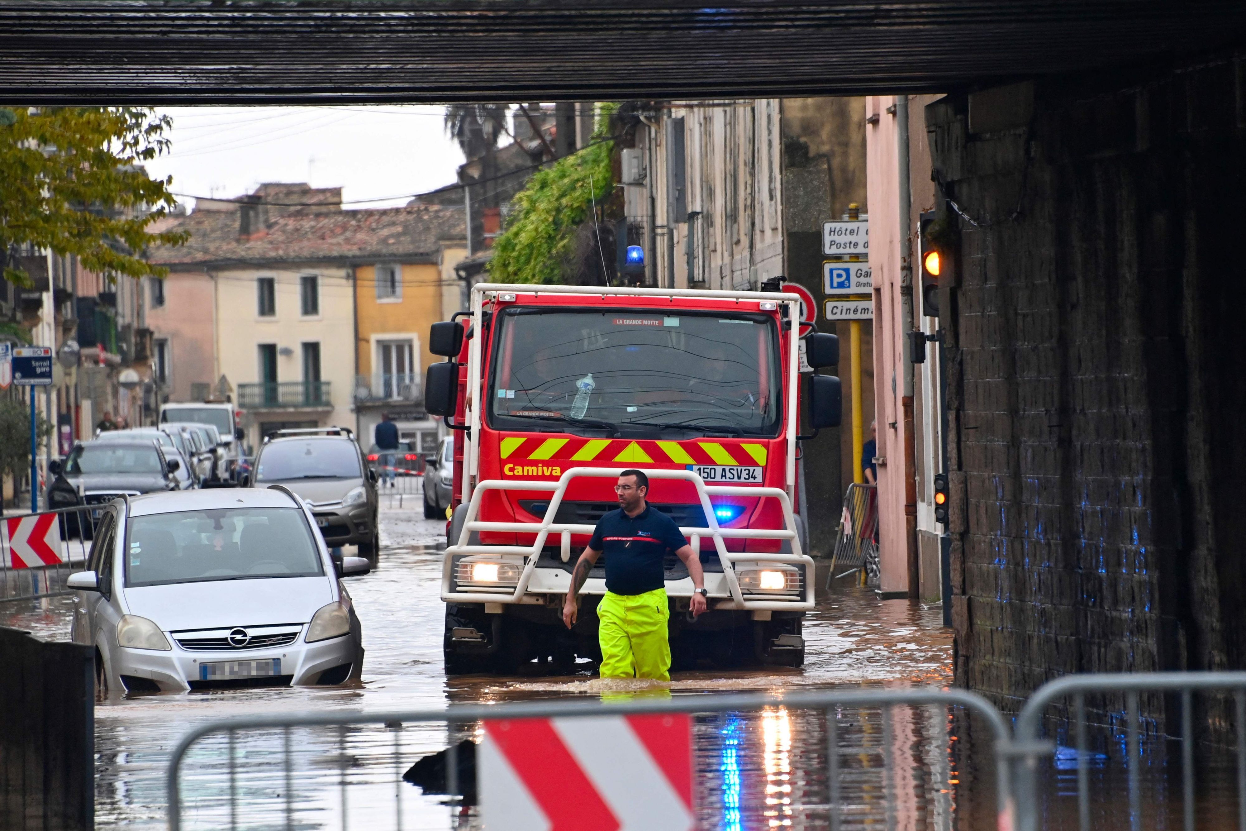 Ein Feuerwehrmann geht nach starken Regenfällen durch eine überflutete Straße in Lunel bei Montpellier in Südfrankreich.