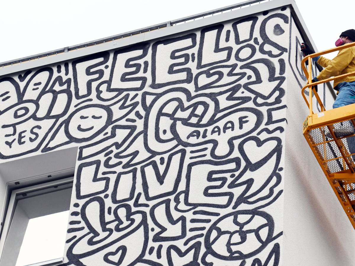 Der New Yorker Künstler Timothy Goodman gestaltet mit seinem Werk „People Love People“ die Fassade eines Hostels.