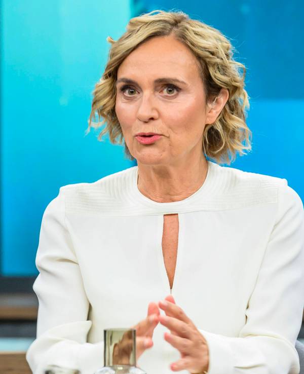 Caren Miosga spricht an einem Tisch.