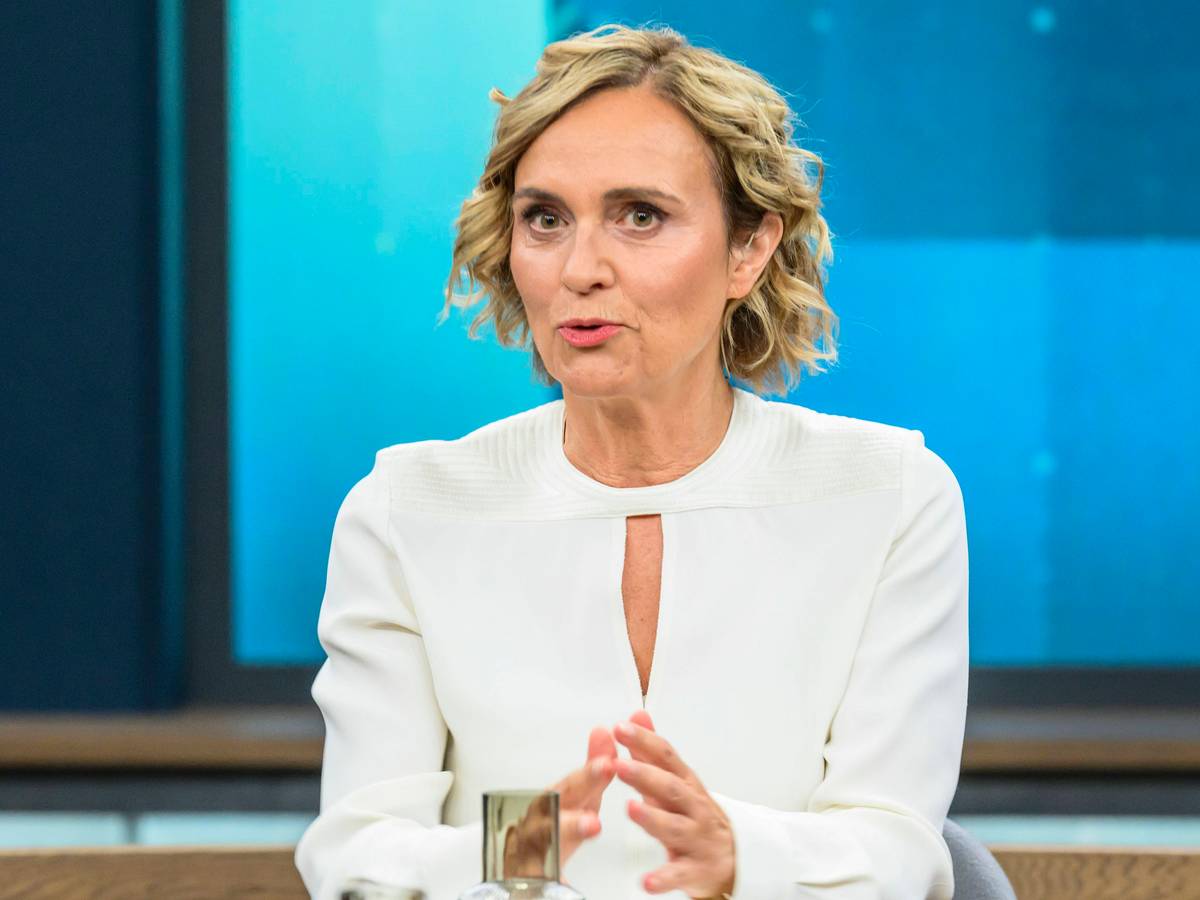 Caren Miosga spricht an einem Tisch.