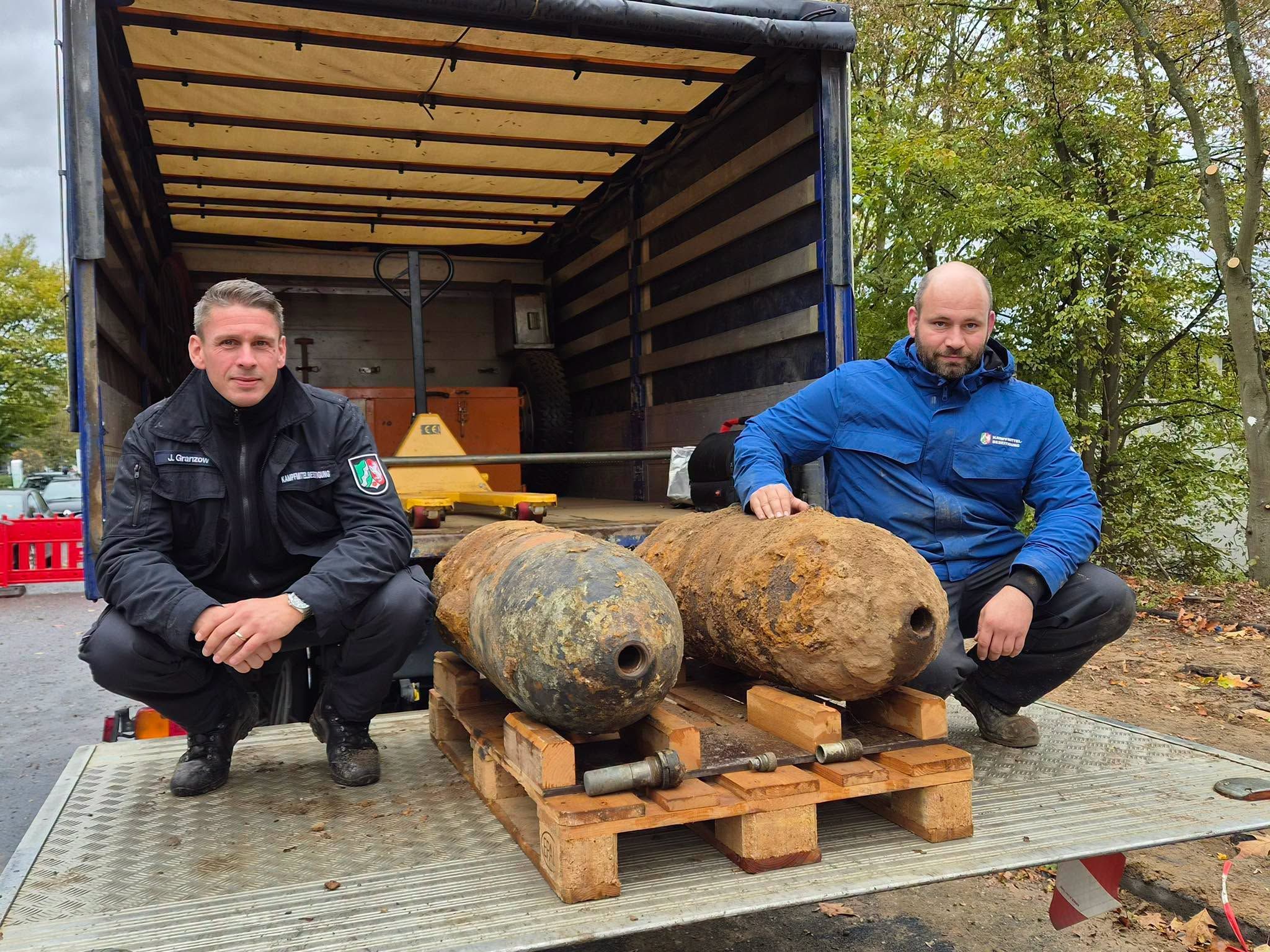 Julian Granzow (Entschärfer) und Alexander Püttmann vom Kampfmittelbeseitigungsdienst mit den beiden entschärften Blindgängern in Neuss.
