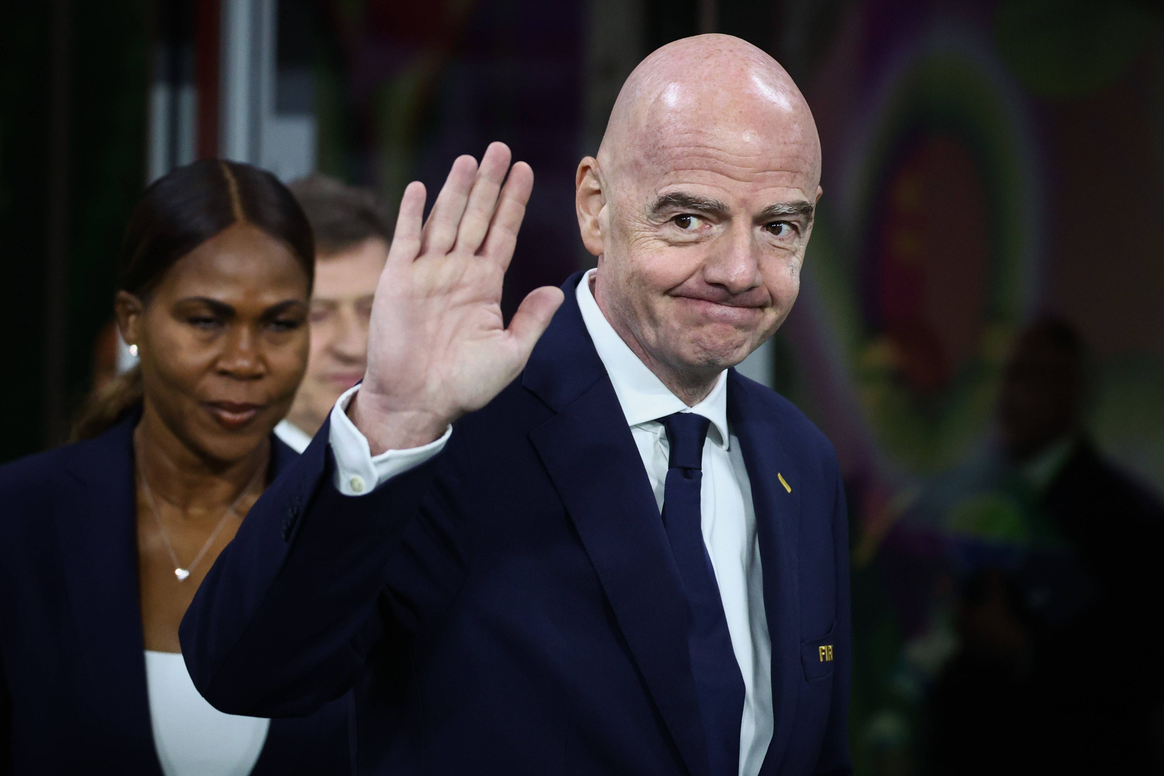 Fifa-Präsident Gianni Infantino hebt Hand in Richtung Kamera.