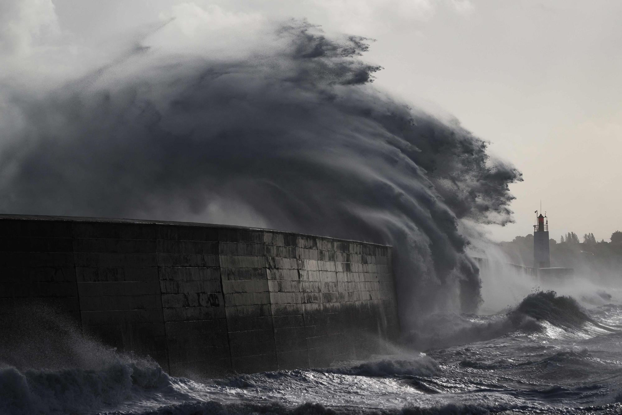 Eine Welle bricht während des Sturms „Austen“ in Saint-Malo im Westen Frankreichs am Leuchtturm „Phare du Mole“. Auch in Hamburg könnte eine Sturmflut auflaufen.