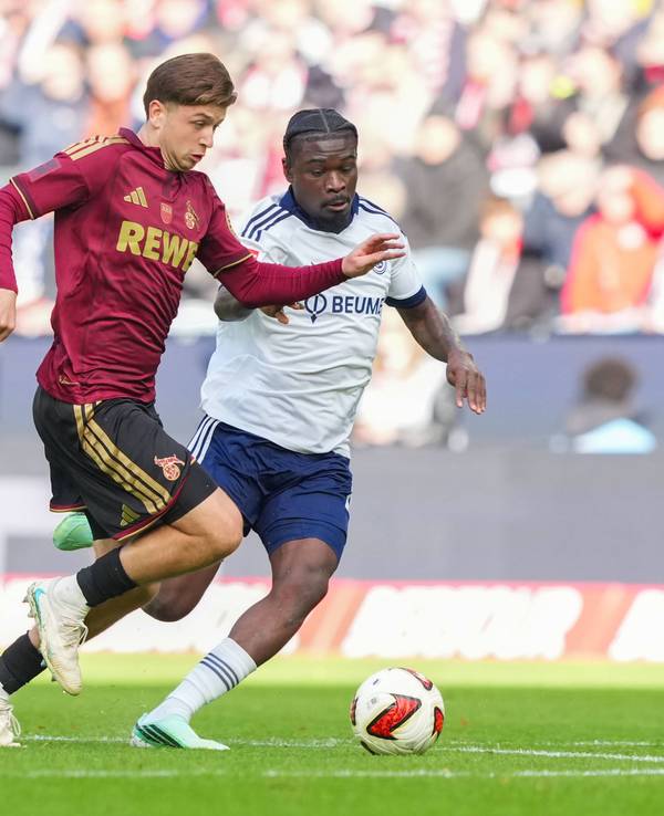 Mikey Moore (1. FC Köln) im Zweikampf gegen Junior Dina Ebimbe (FC Schalke 04).