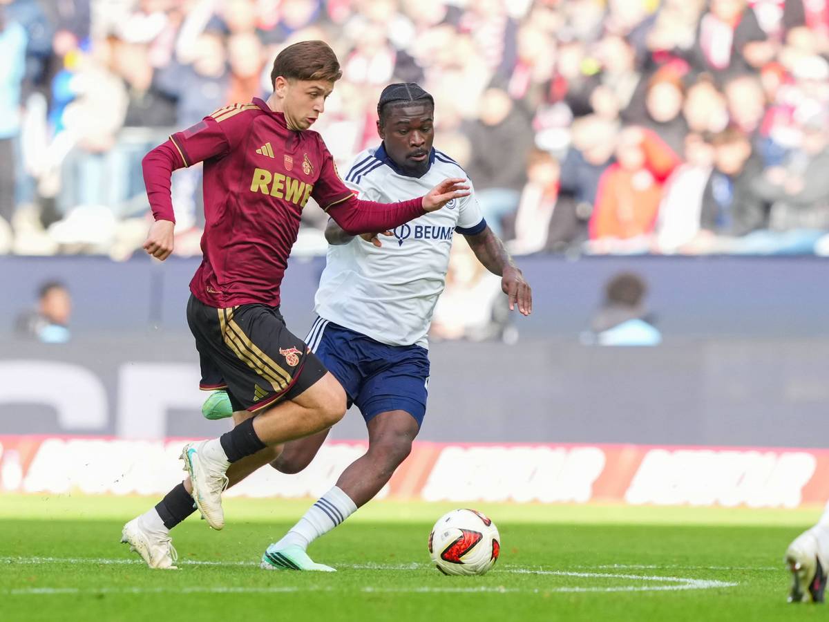 Mikey Moore (1. FC Köln) im Zweikampf gegen Junior Dina Ebimbe (FC Schalke 04).