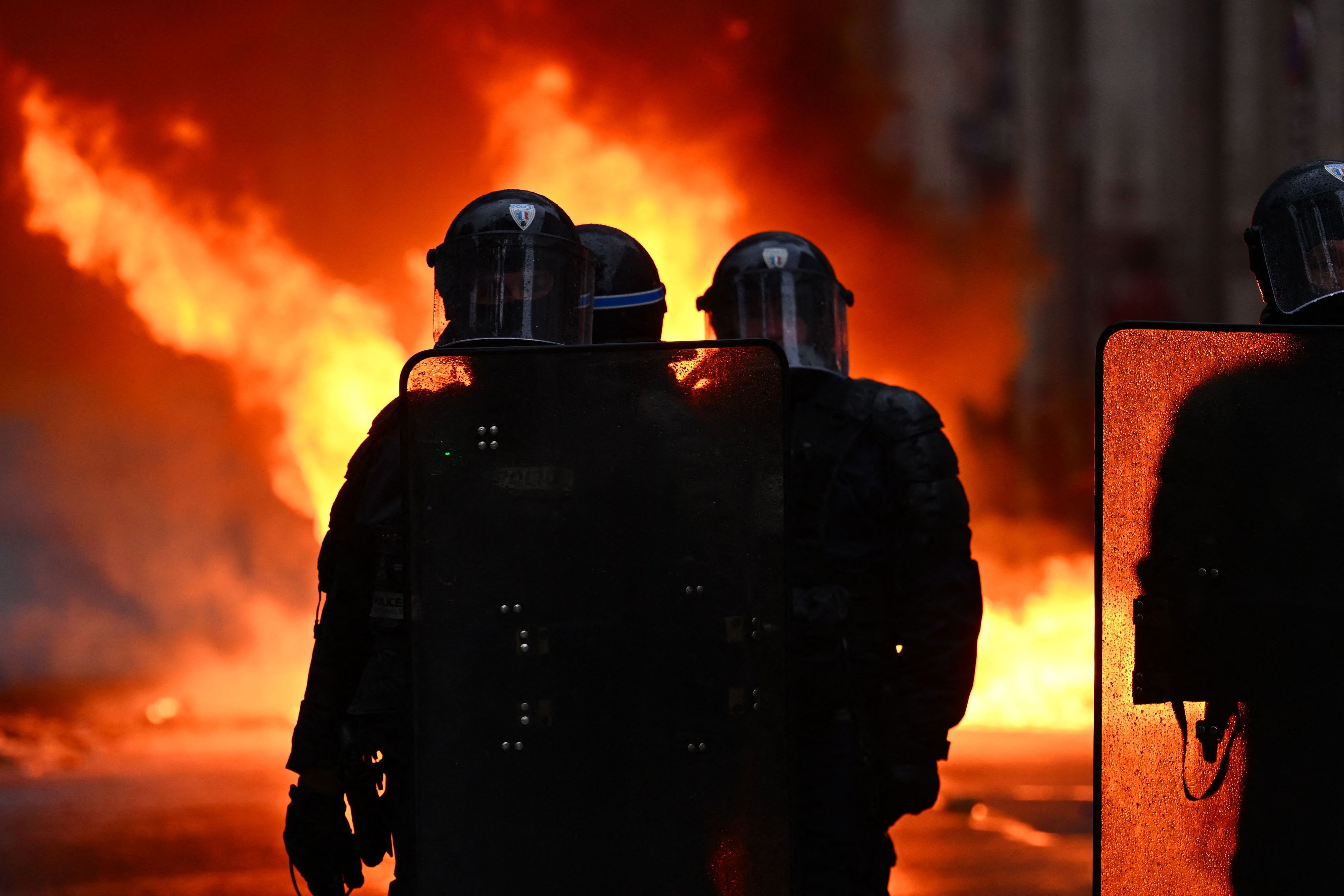 Polizisten stehen vor den Flammen, als am rande der Demonstrationen in Nantes im Westen Frankreichs Brände ausbrachen.