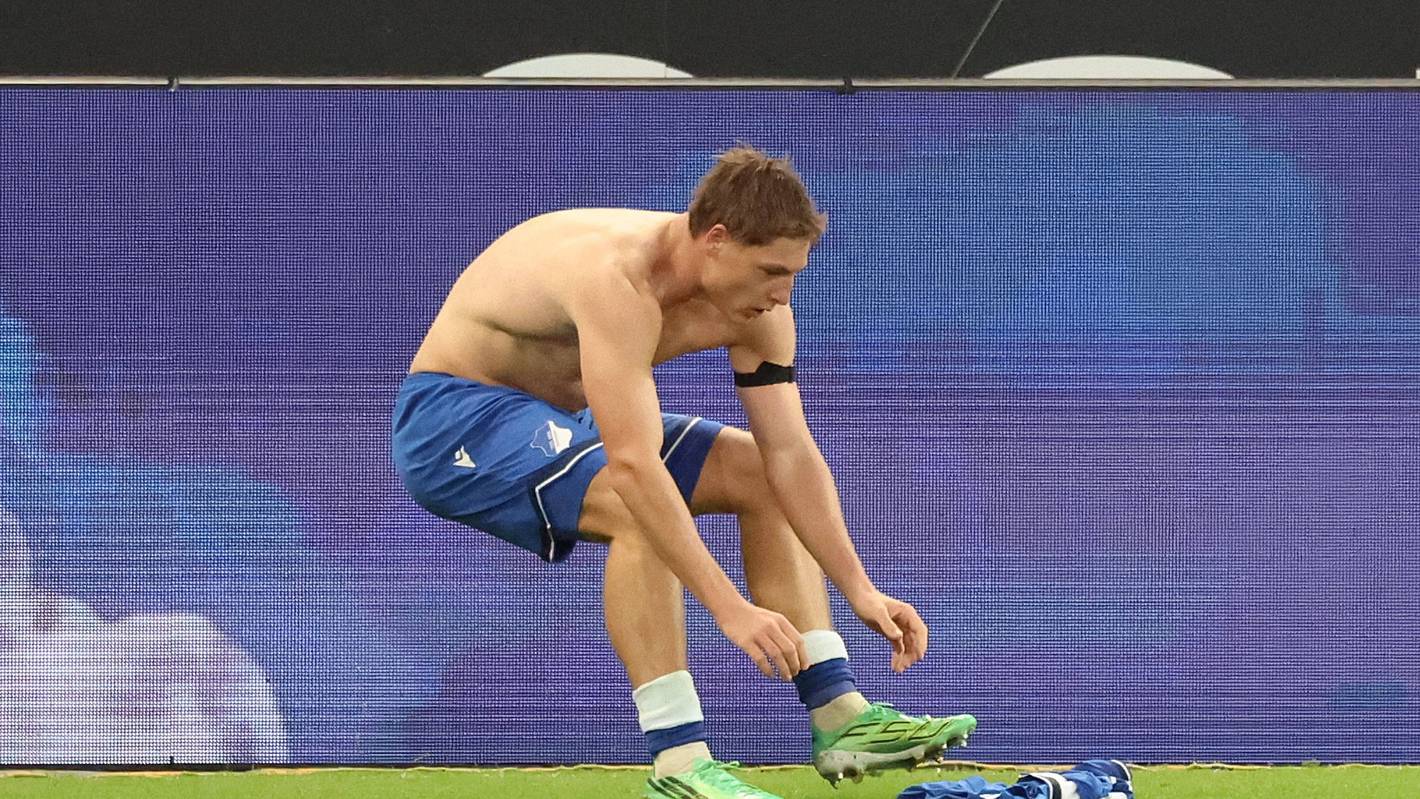 Alexander Prass hebt sein Trikot vom Rasen auf.