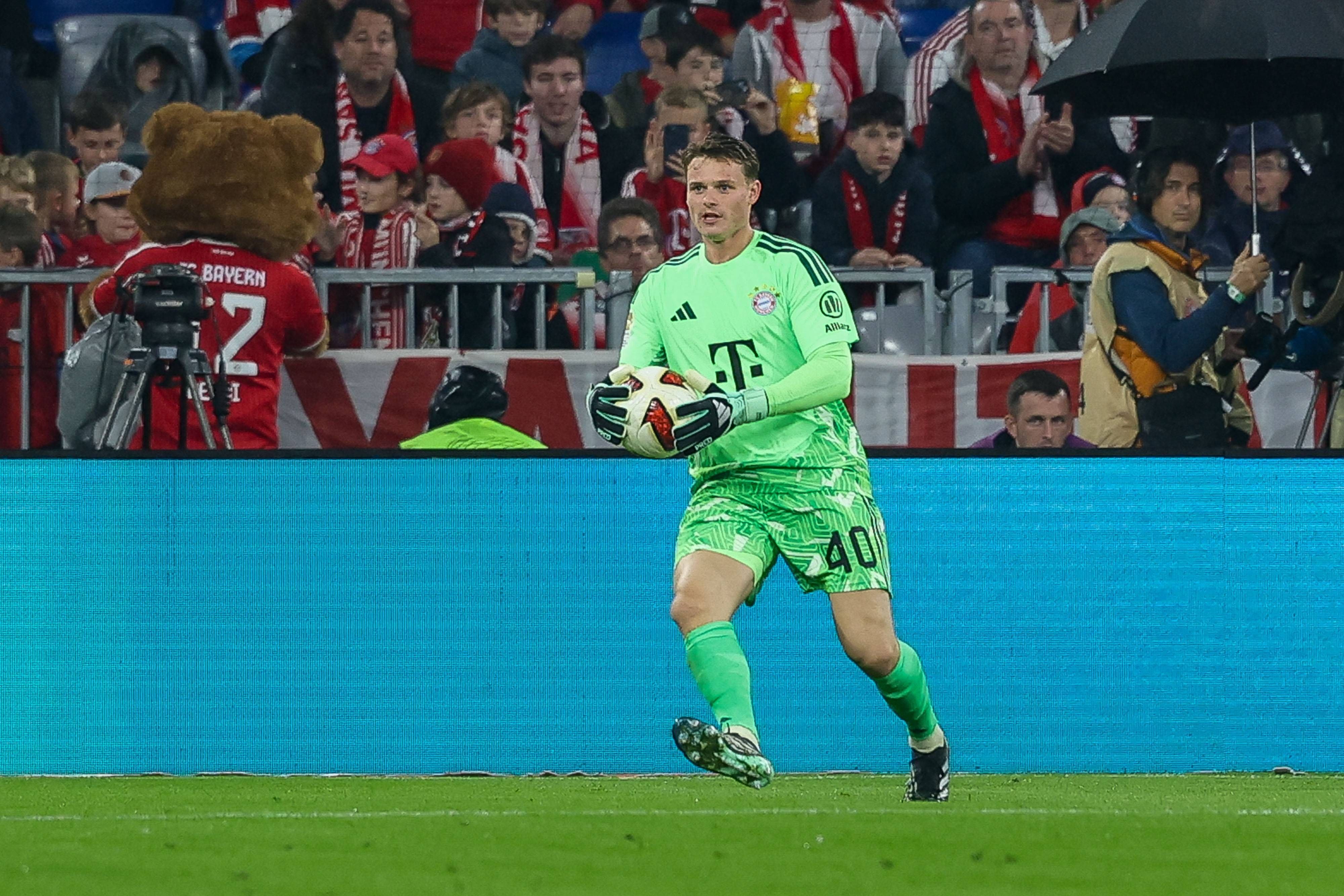Jonas Urbig hält einen Ball in den Händen.