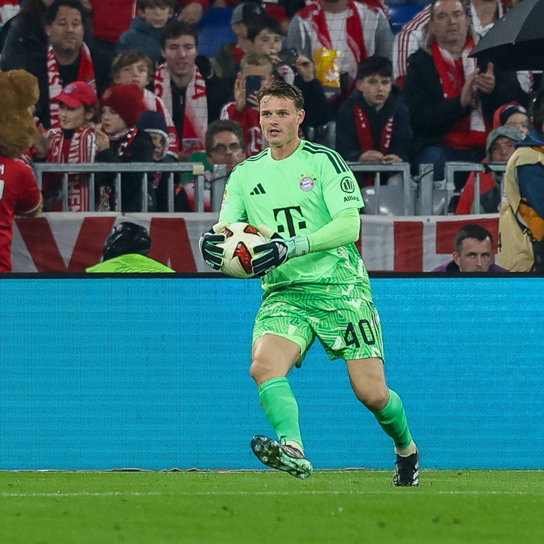 Jonas Urbig hält einen Ball in den Händen.