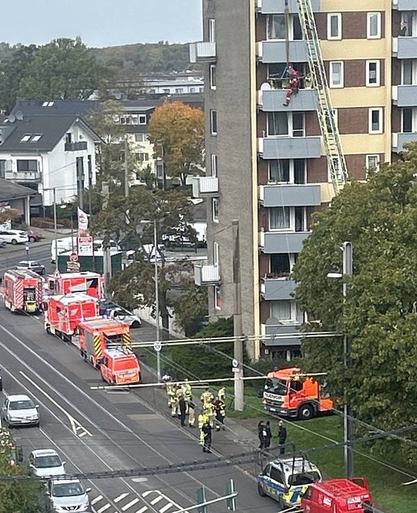 An einem Hochhaus läuft ein Einsatz von Feuerwehr, Polizei, Rettungsdienst und Höhenrettung.