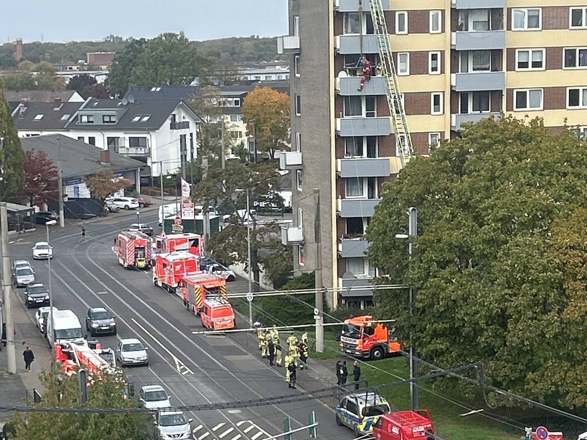An einem Hochhaus läuft ein Einsatz von Feuerwehr, Polizei, Rettungsdienst und Höhenrettung.