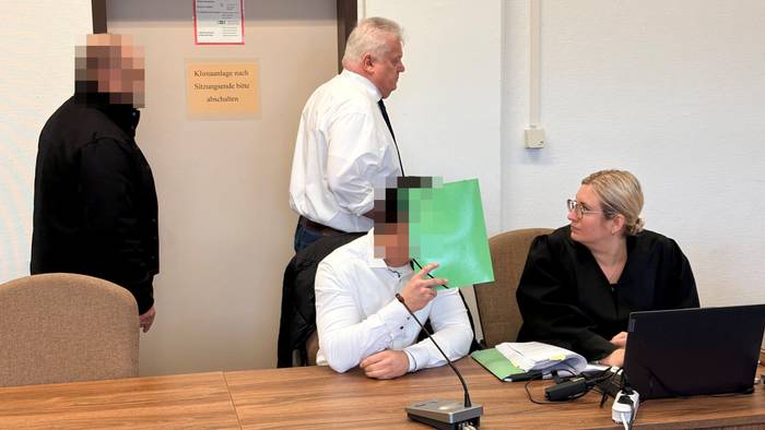 Die beiden angeklagten Polizisten mit ihren Anwälten Michael Emde und Daniela Rohe beim Prozessauftakt im Landgericht Köln