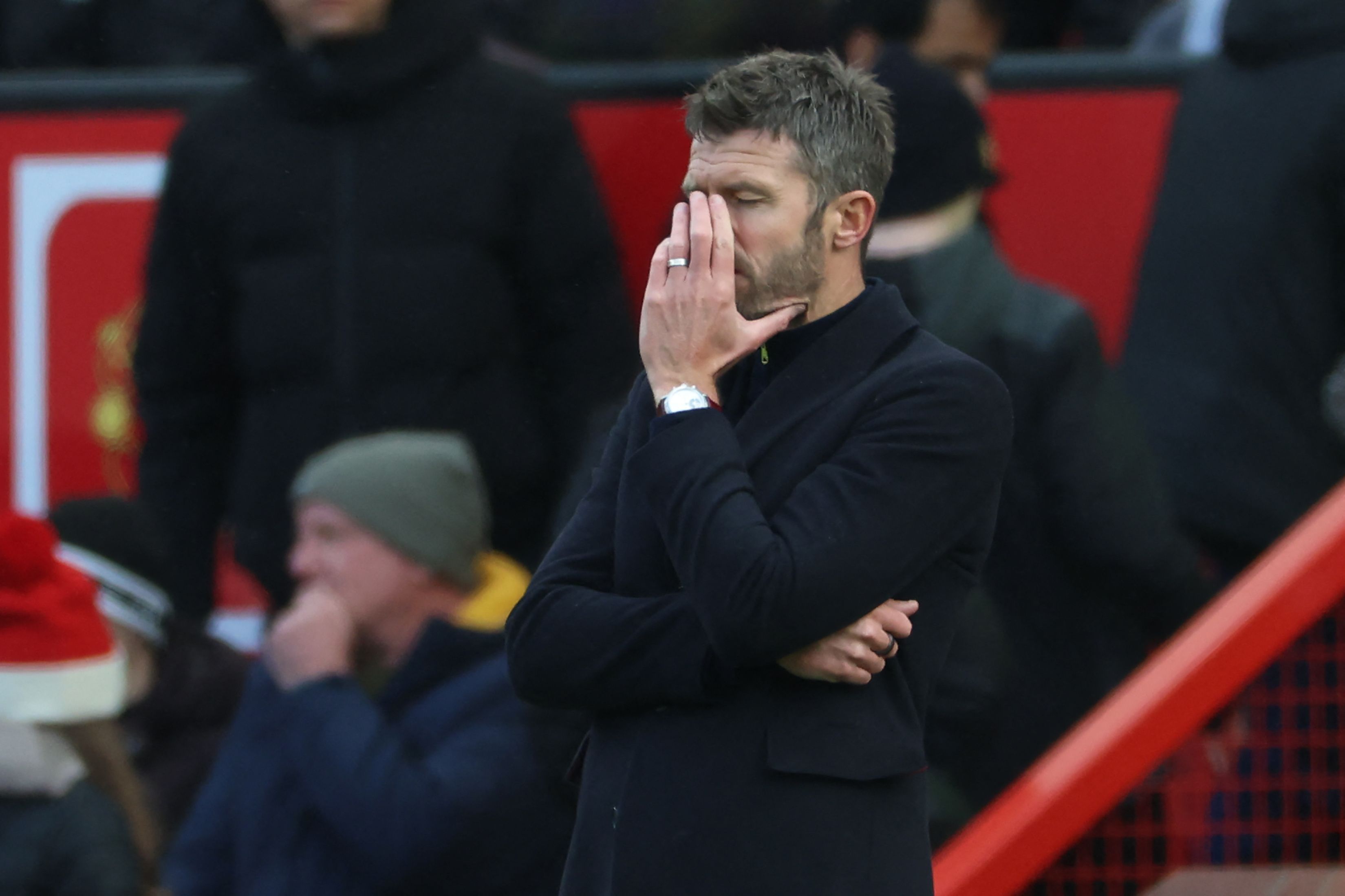 United-Trainer Michael Carrick steht an der Seitenlinie und hält sich die Hand ins Gesicht.