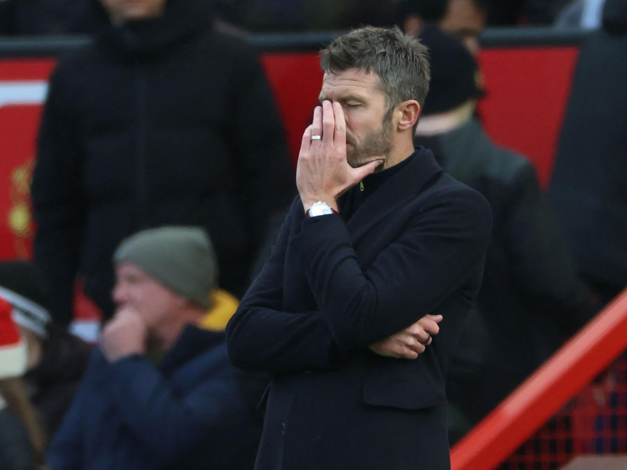 United-Trainer Michael Carrick steht an der Seitenlinie und hält sich die Hand ins Gesicht.