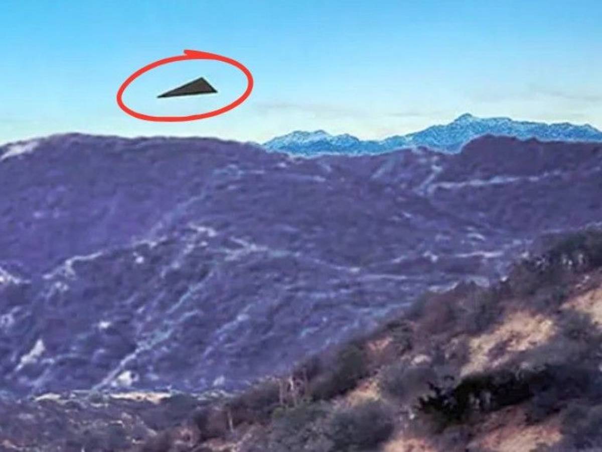 Ein Bild, das zusammen mit einem FBI-Bericht aus dem Jahr 2026 veröffentlicht wurde, zeigt ein schwarzes, dreieckiges Objekt über bergigem Gelände.