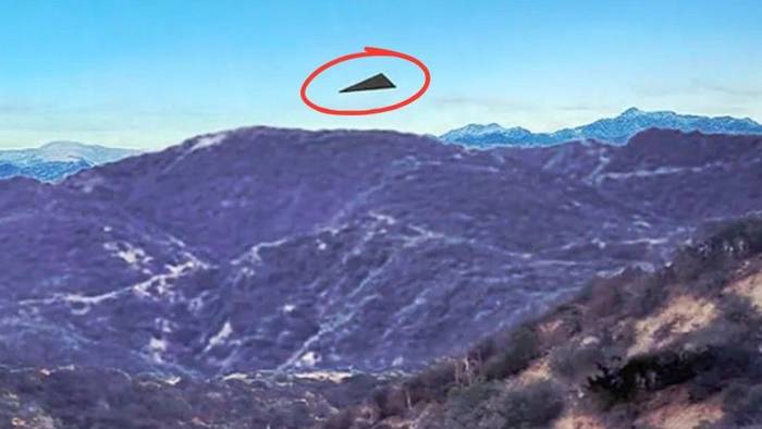 Ein Bild, das zusammen mit einem FBI-Bericht aus dem Jahr 2026 veröffentlicht wurde, zeigt ein schwarzes, dreieckiges Objekt über bergigem Gelände.