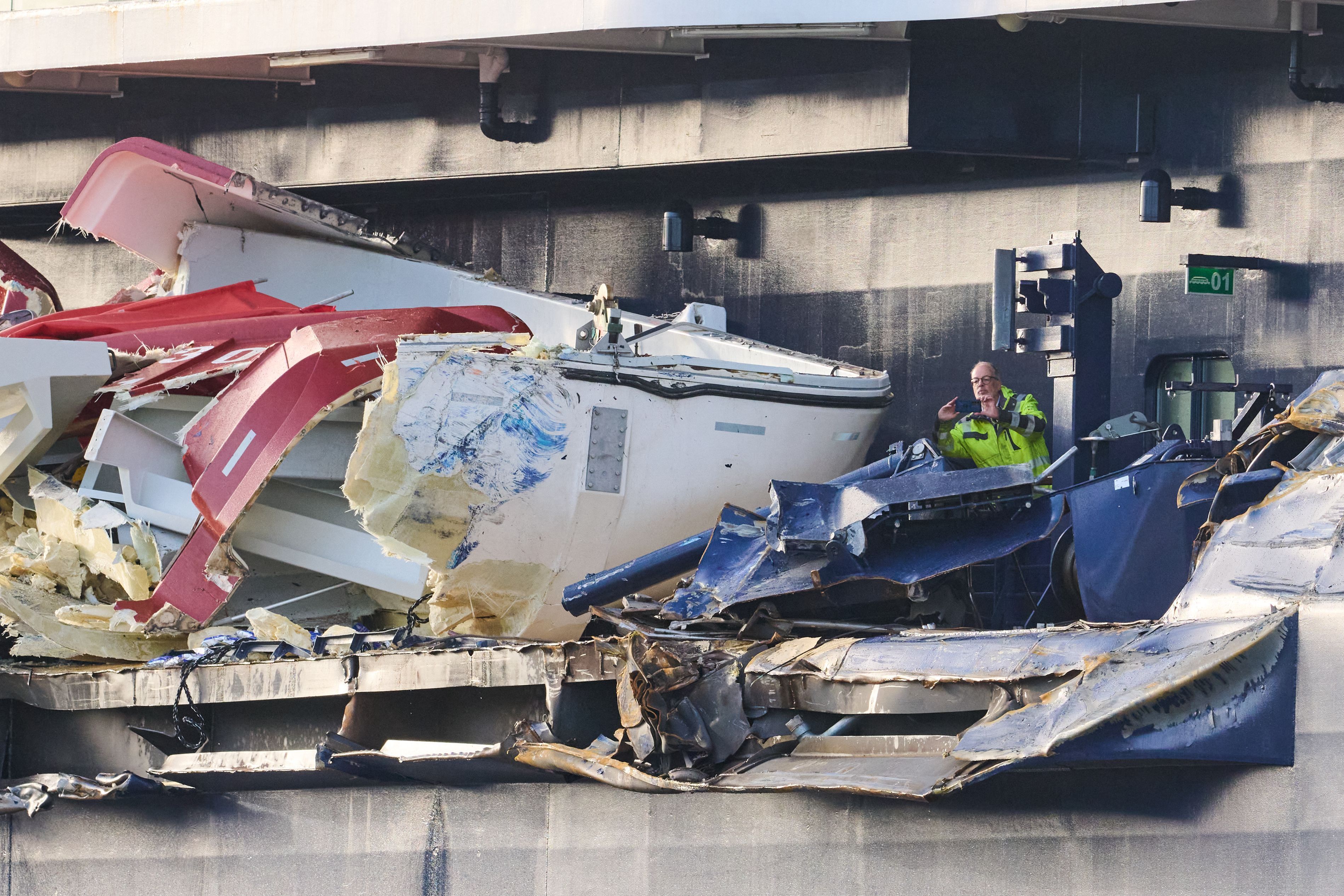 Zwei Männer begutachten den Schaden an der „Mein Schiff 3“. Das Kreuzfahrtschiff war am Vortag bei stürmischem Wetter mit zwei Containerschiffen kollidiert.