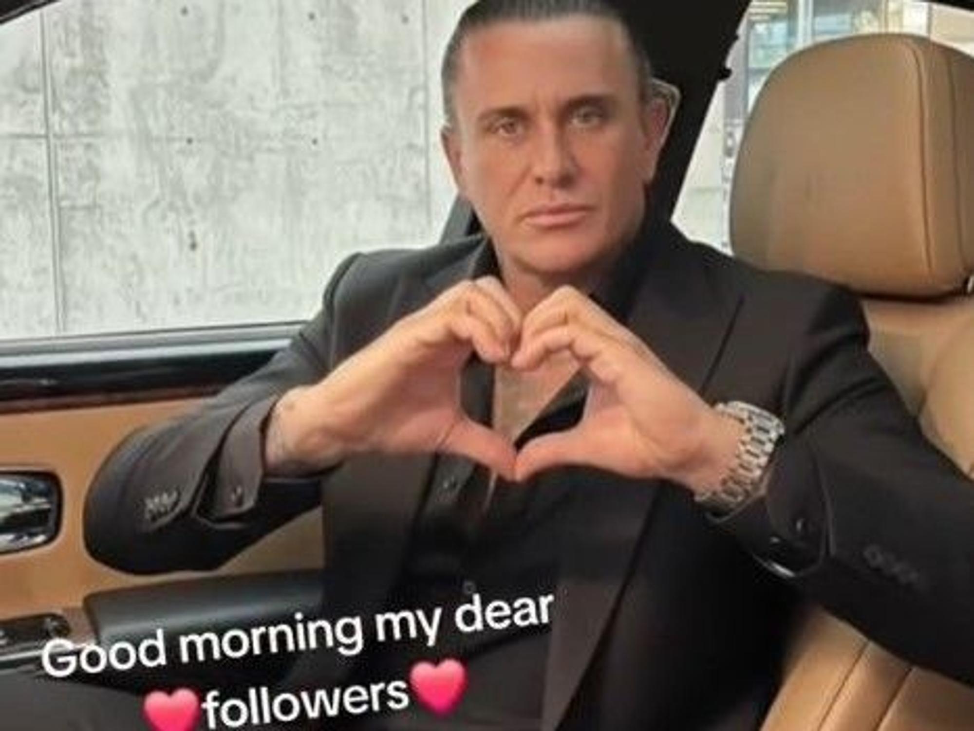Neco Arabaci sitzt in einem Luxusauto und grüßt seine Follower.