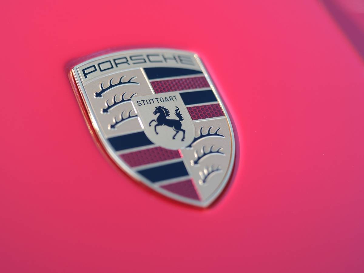 Der Schriftzug des Stuttgarter Sportwagenherstellers Porsche auf der Motorhaube eines roten Porsche-Sportwagens.