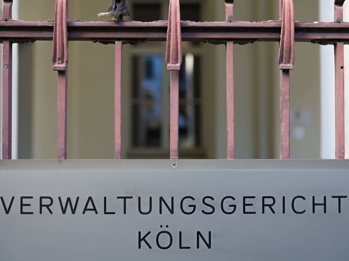 Ein Schild hängt am Eingang zum Verwaltungsgericht in Köln. +