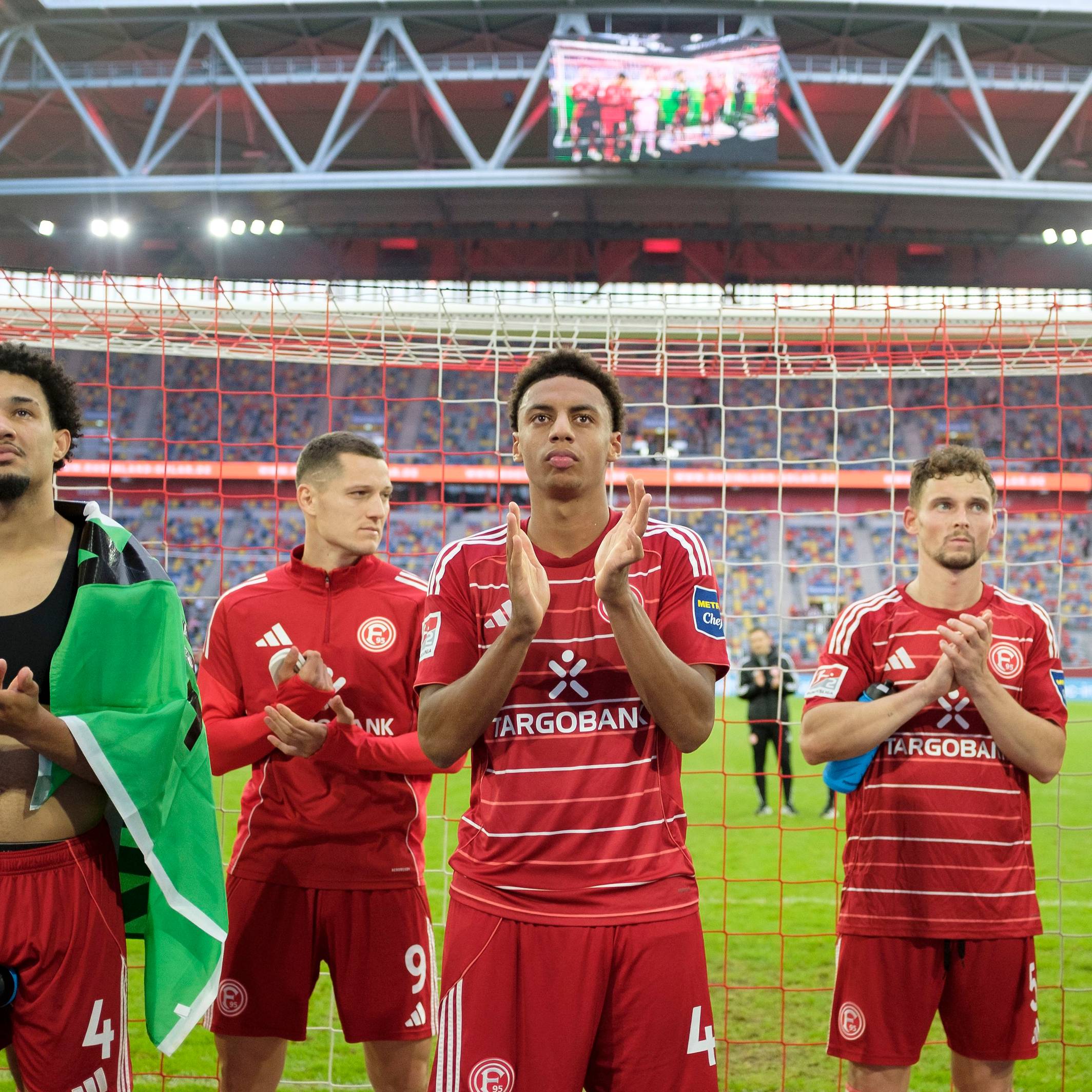 Die Spieler von Fortuna Düsseldorf stehen vor der Kurve und klatschen in ihre Hände.