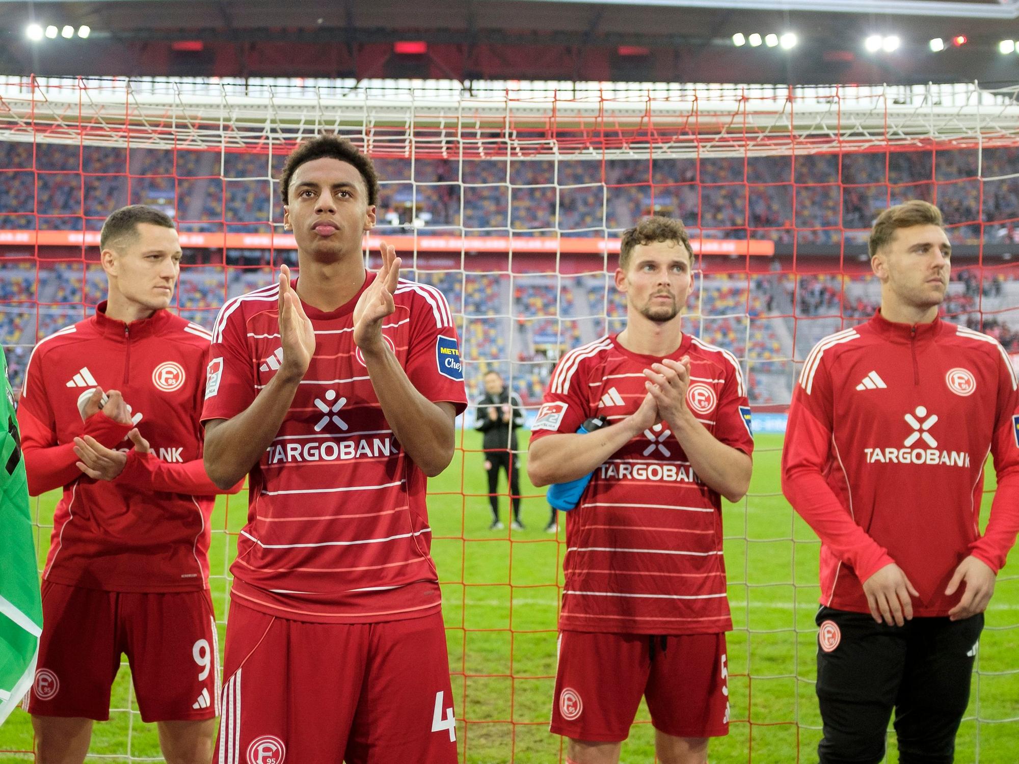 Die Spieler von Fortuna Düsseldorf stehen vor der Kurve und klatschen in ihre Hände.
