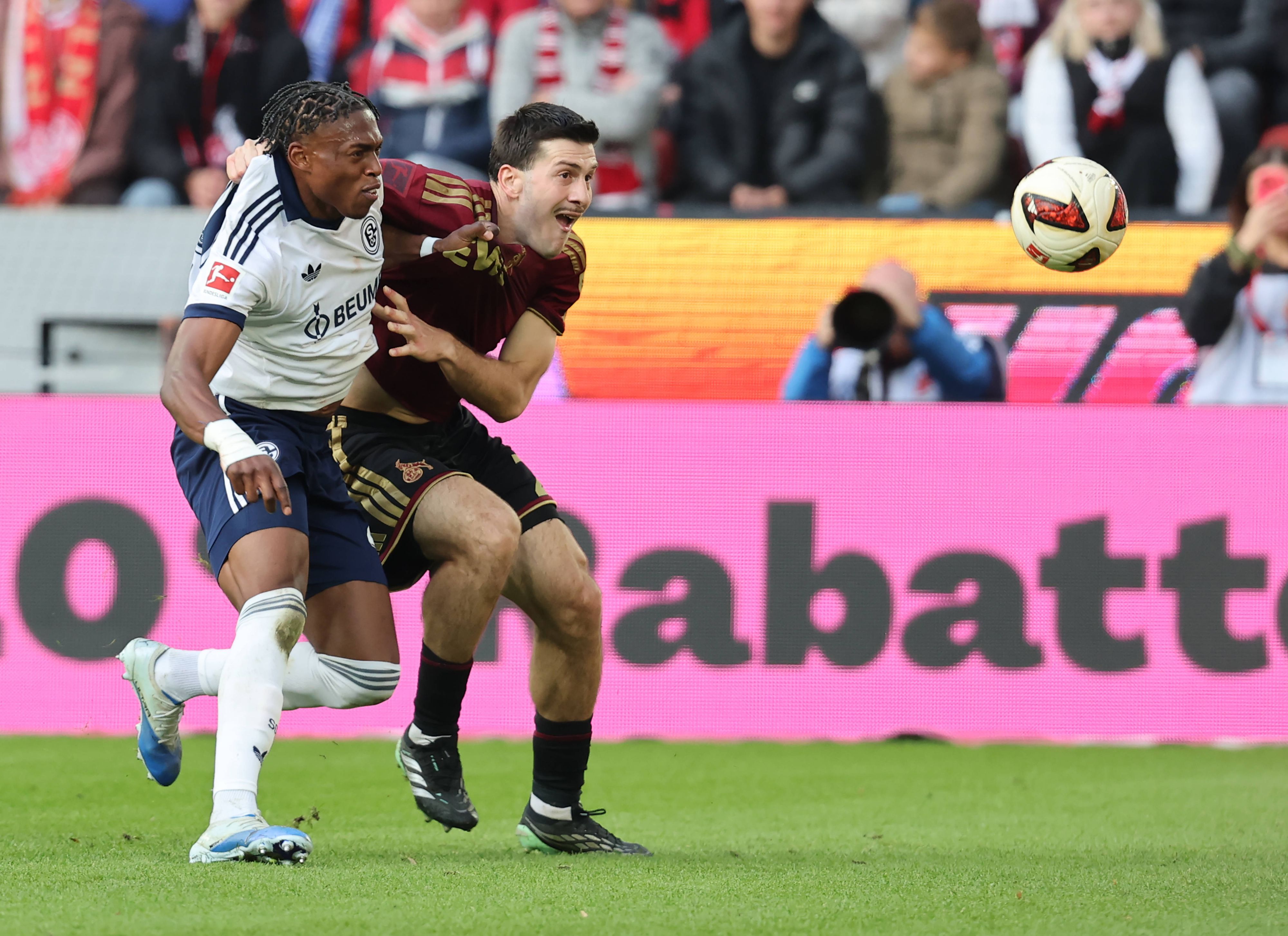 Junior Adamu (Schalke 04) und Luka Lochoshvili (1. FC Köln) kämpfen um den Ball.