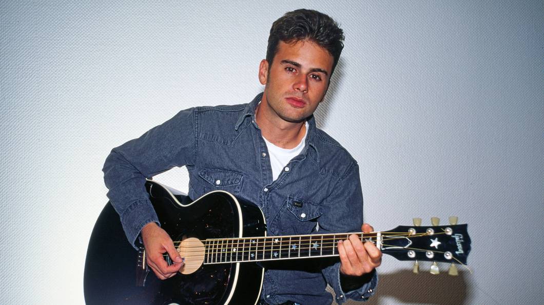 Jamie Walters posiert mit Gitarre.