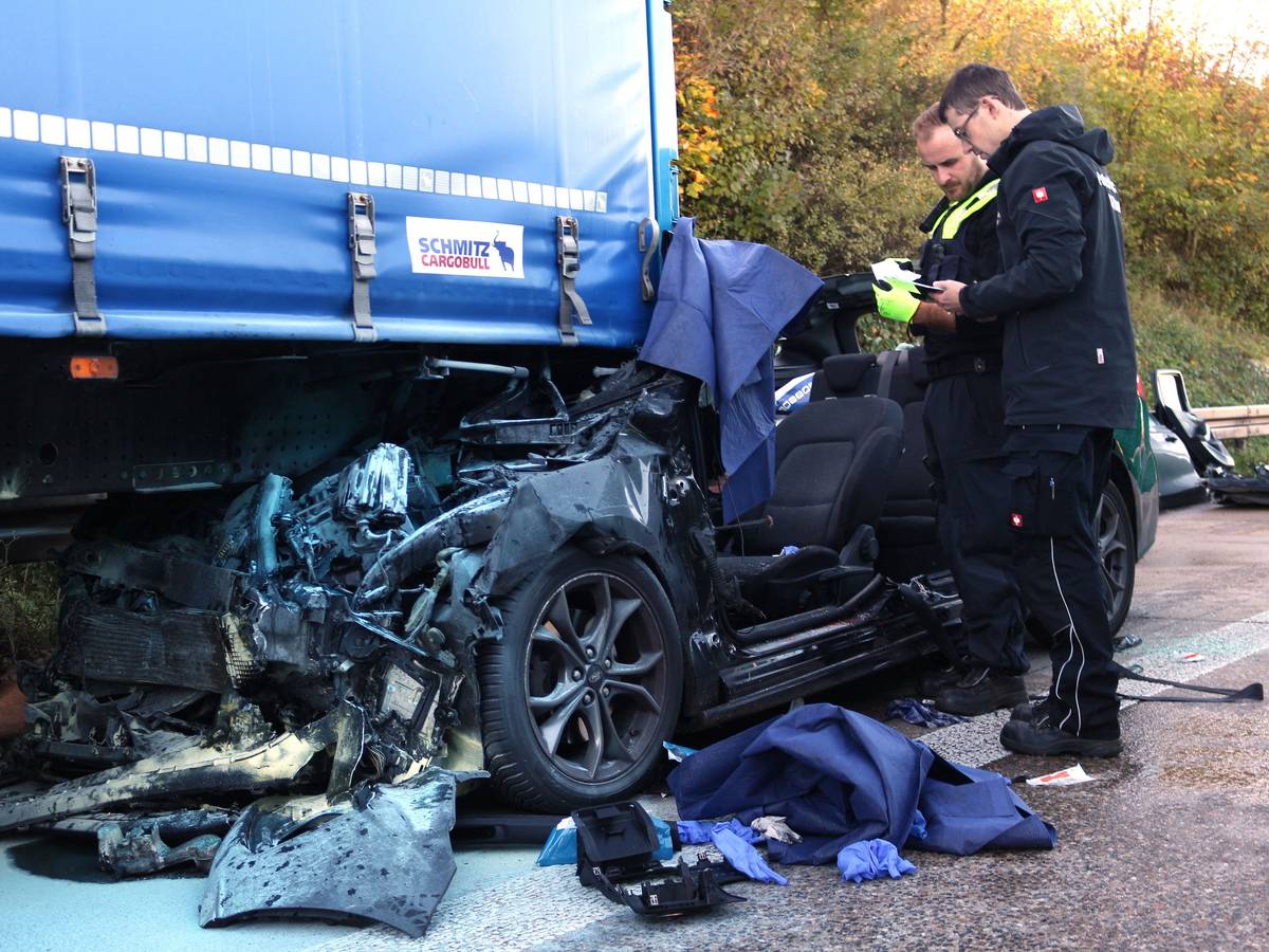 Einsatzkräfte der Polizei arbeiten an einem Unfallfahrzeug.