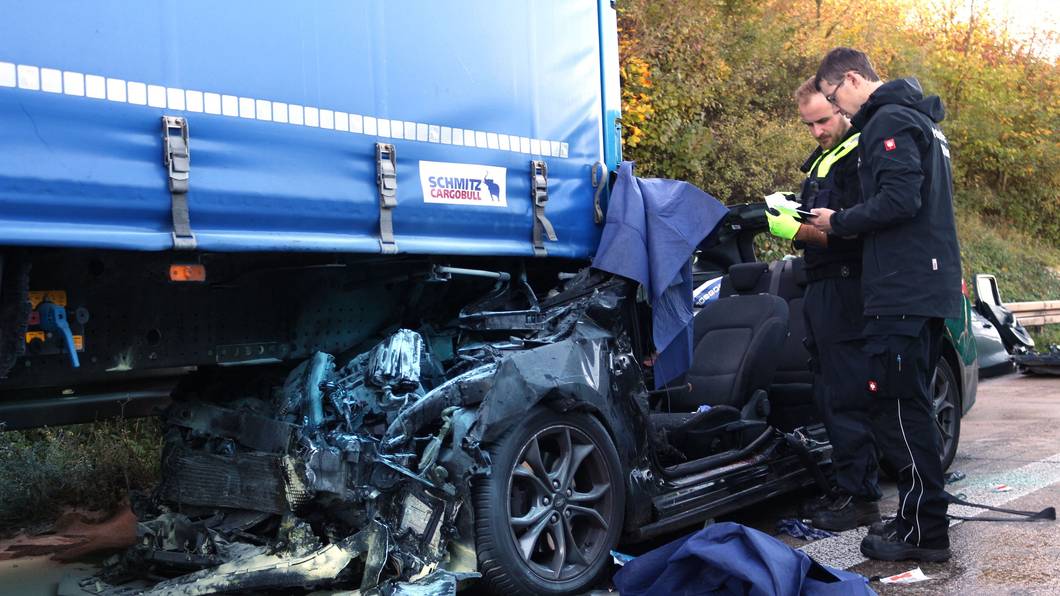 Einsatzkräfte der Polizei arbeiten an einem Unfallfahrzeug.