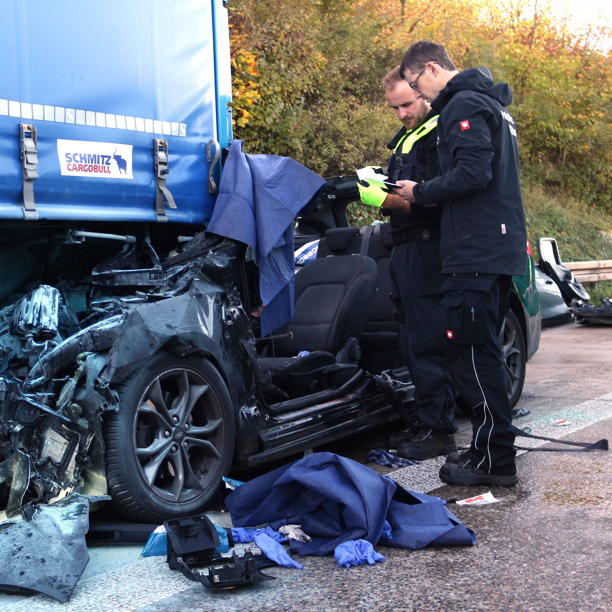 Einsatzkräfte der Polizei arbeiten an einem Unfallfahrzeug.