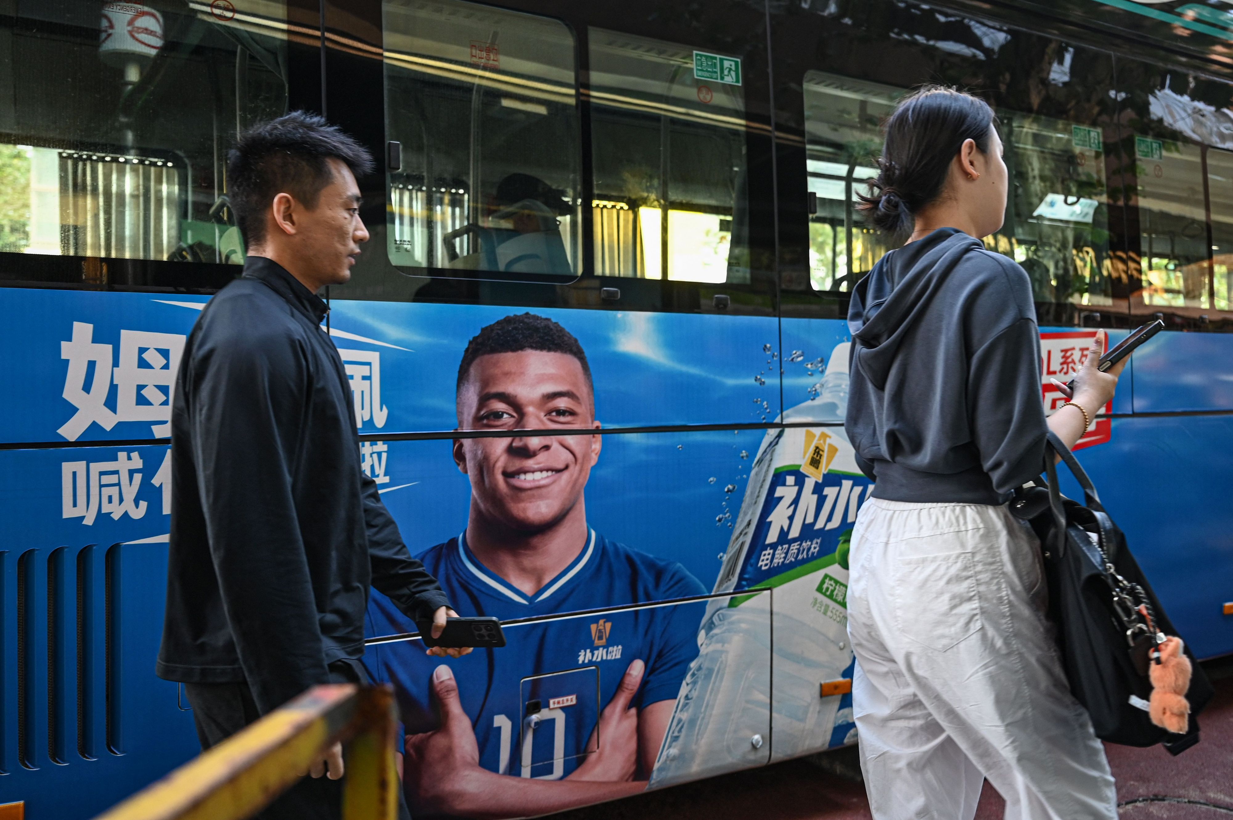 Ein Bild von Fußballstar Mbappé auf einem chinesischen Bus