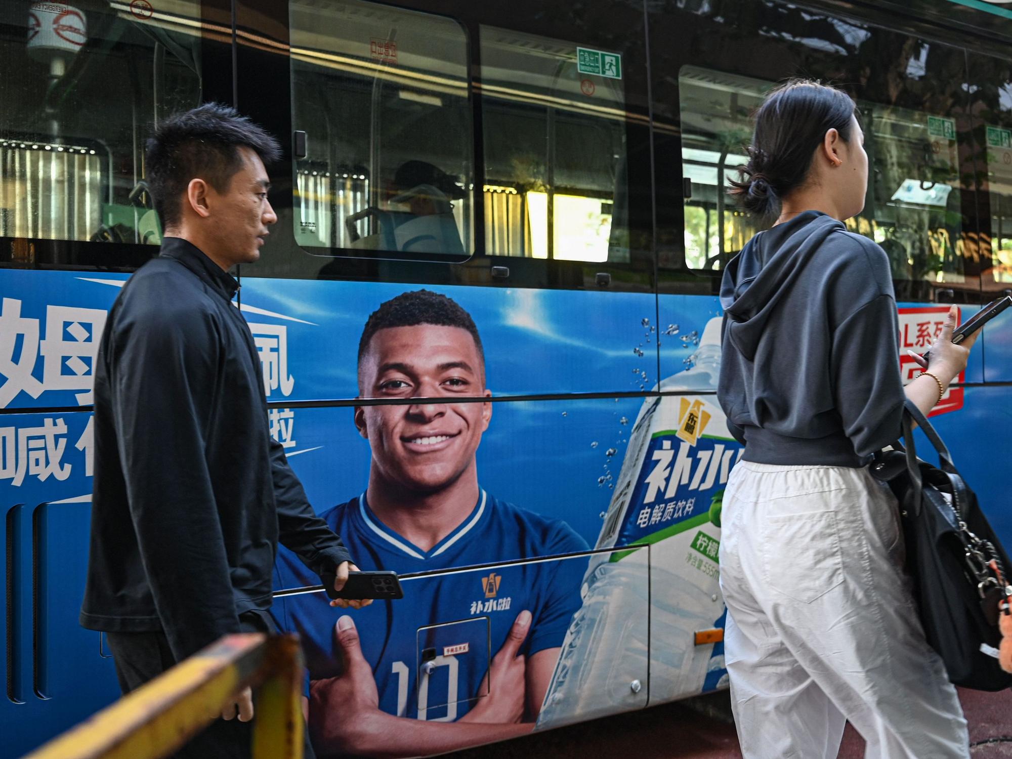 Ein Bild von Fußballstar Mbappé auf einem chinesischen Bus