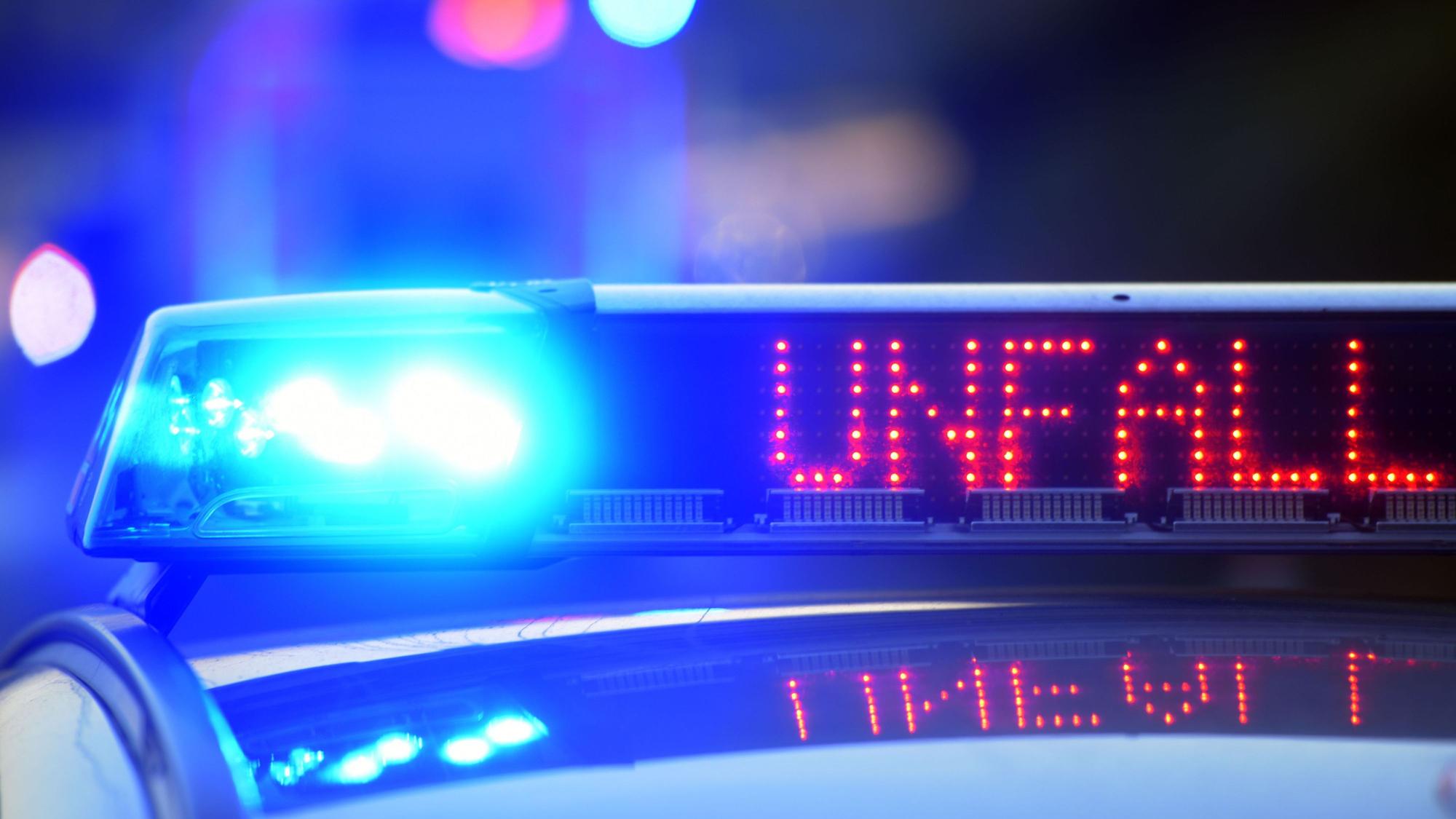 Auf einem Polizeifahrzeug warnt eine Leuchtschrift vor einer Unfallstelle.