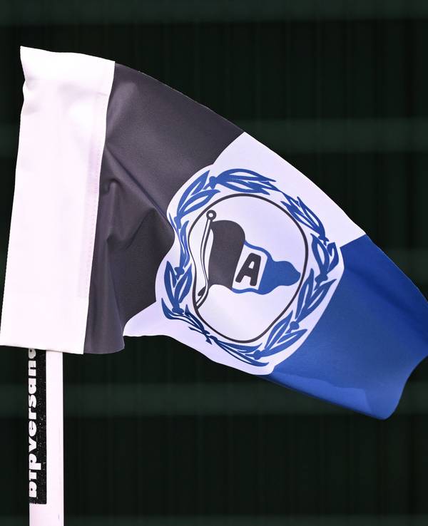 Eckfahne mit dem Logo von Arminia Bielefeld vor scharzem Hintergrund.