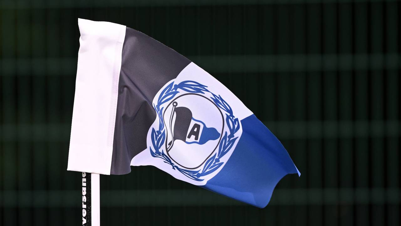 Eckfahne mit dem Logo von Arminia Bielefeld vor scharzem Hintergrund.