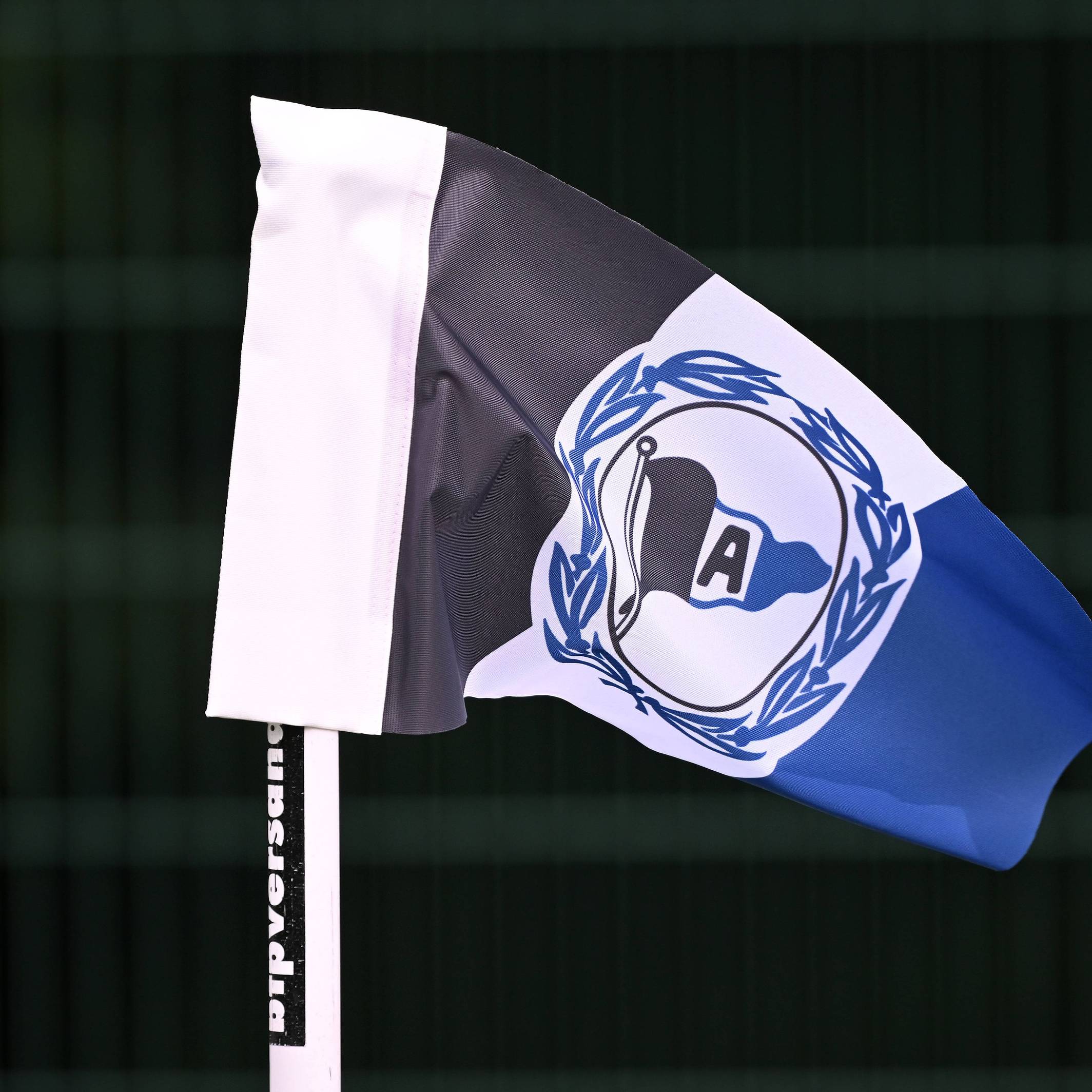 Eckfahne mit dem Logo von Arminia Bielefeld vor scharzem Hintergrund.