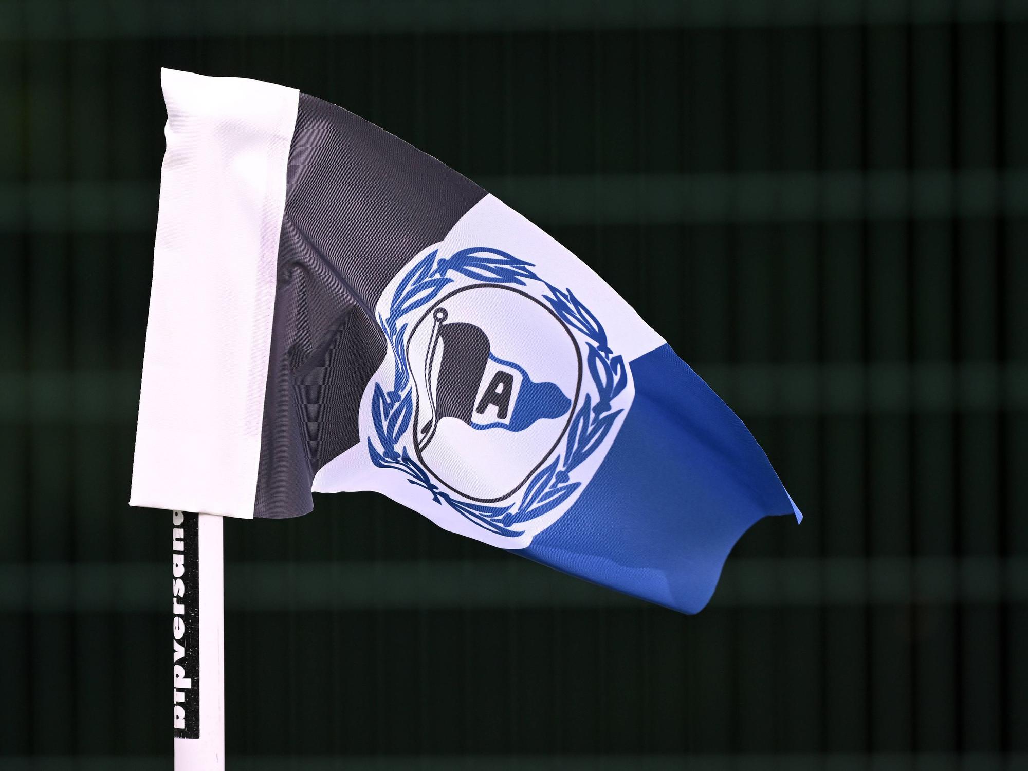Eckfahne mit dem Logo von Arminia Bielefeld vor scharzem Hintergrund.