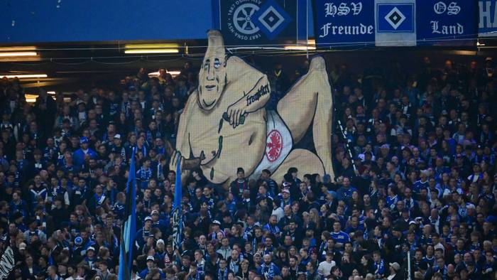 Ein Banner in einem Fußballstadion zeigt einen dickbäuchigen Mann, der nur eine Unterhose mit dem Emblem der Eintracht Frankfurt trägt.