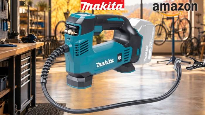 Makita DMP180Z Akku-Kompressor vor Fahrradwerkstatt im Hintergrund.